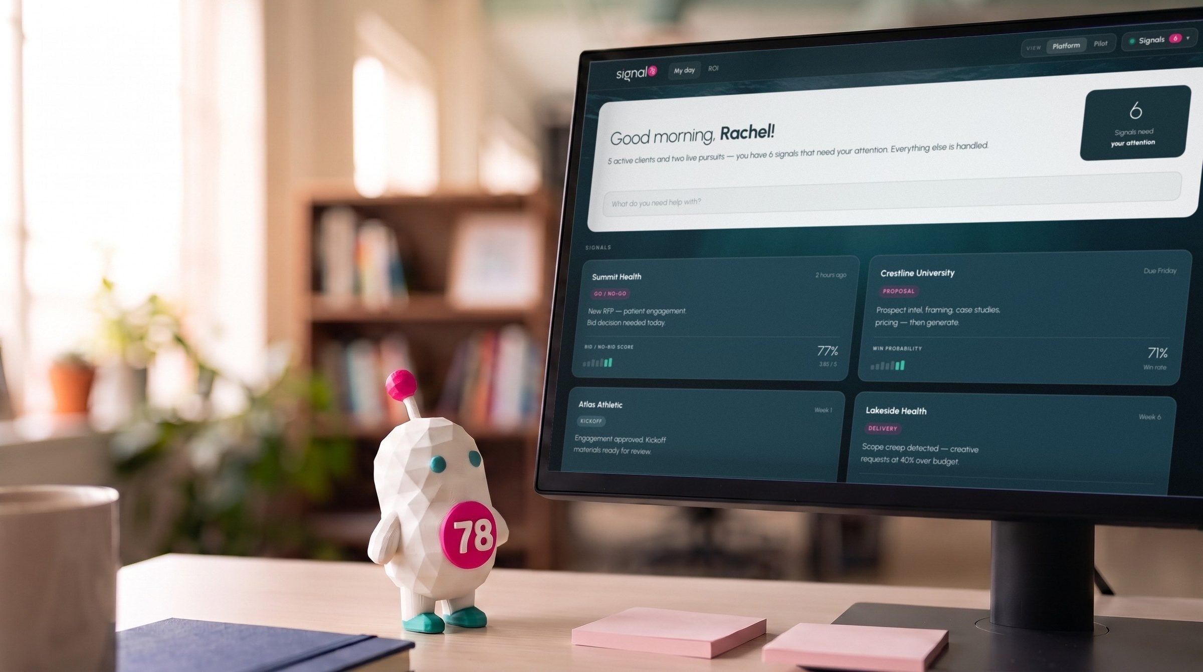 Siggy, the Signal78 mascot, on a desk beside a monitor showing the Signal78 My day screen